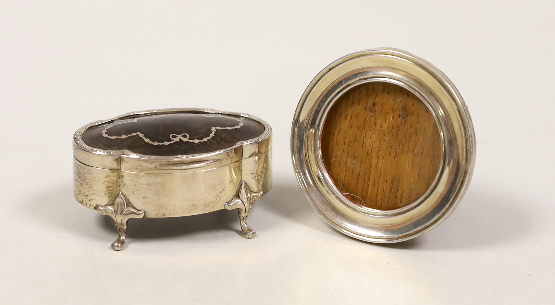 A small George V silver and piqué mounted trinket box, Chester, 1912, 79mm and a small circular silver mounted photograph frame.